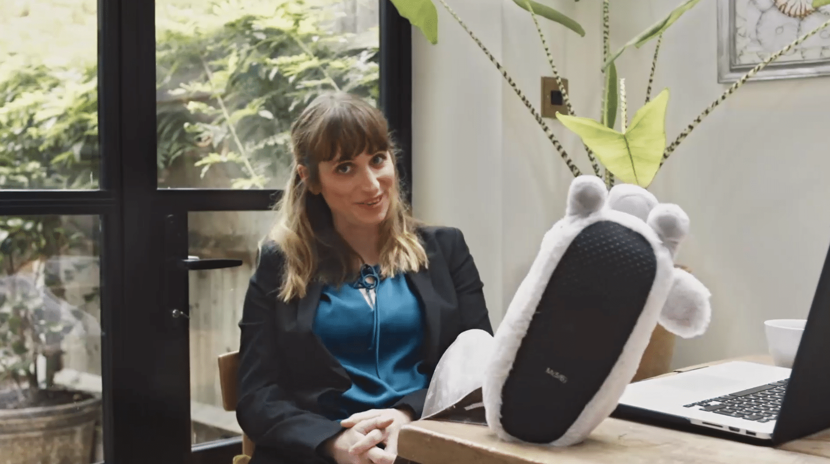 Woman sat at desk with feet up, showing her fuzzy slippers