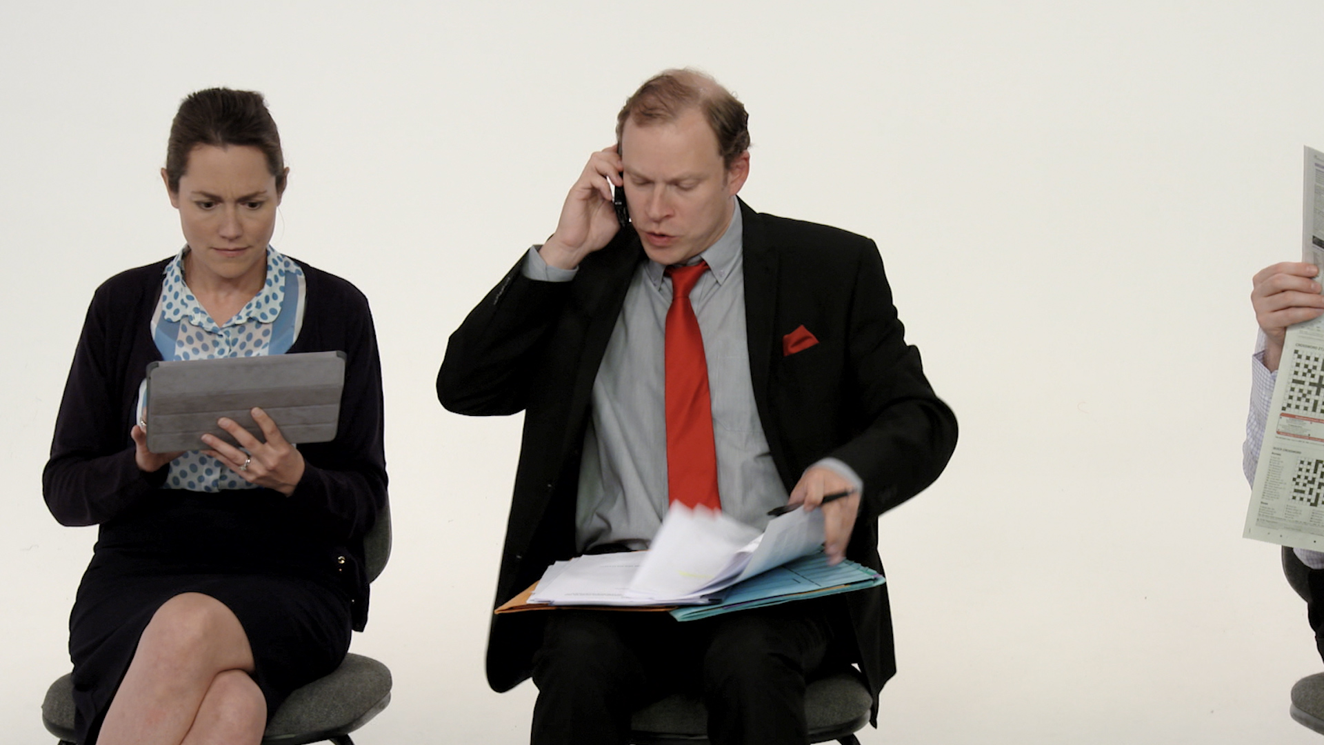 Robert Webb on the phone next to woman on her ipad.
