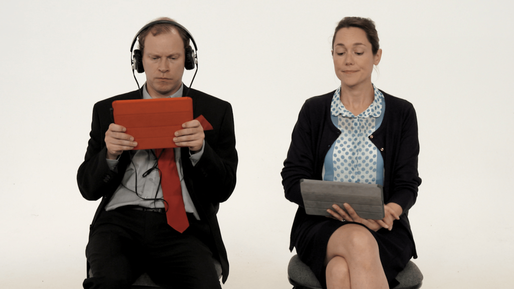Robert Web from Leadership Series on an iPad with headphones on next to woman sitting beside him