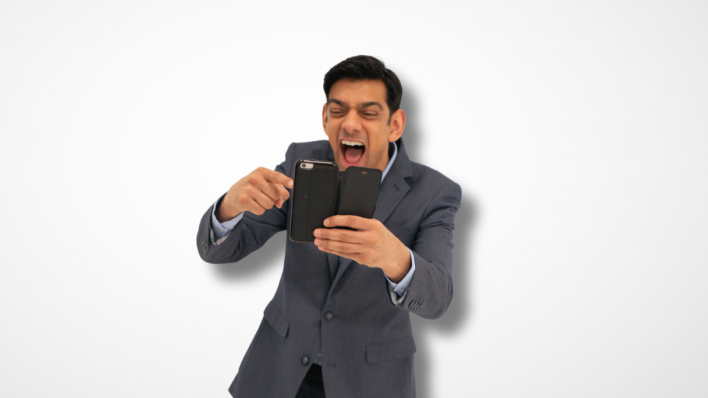 Man laughing manically at something on his phone while pointing at it.